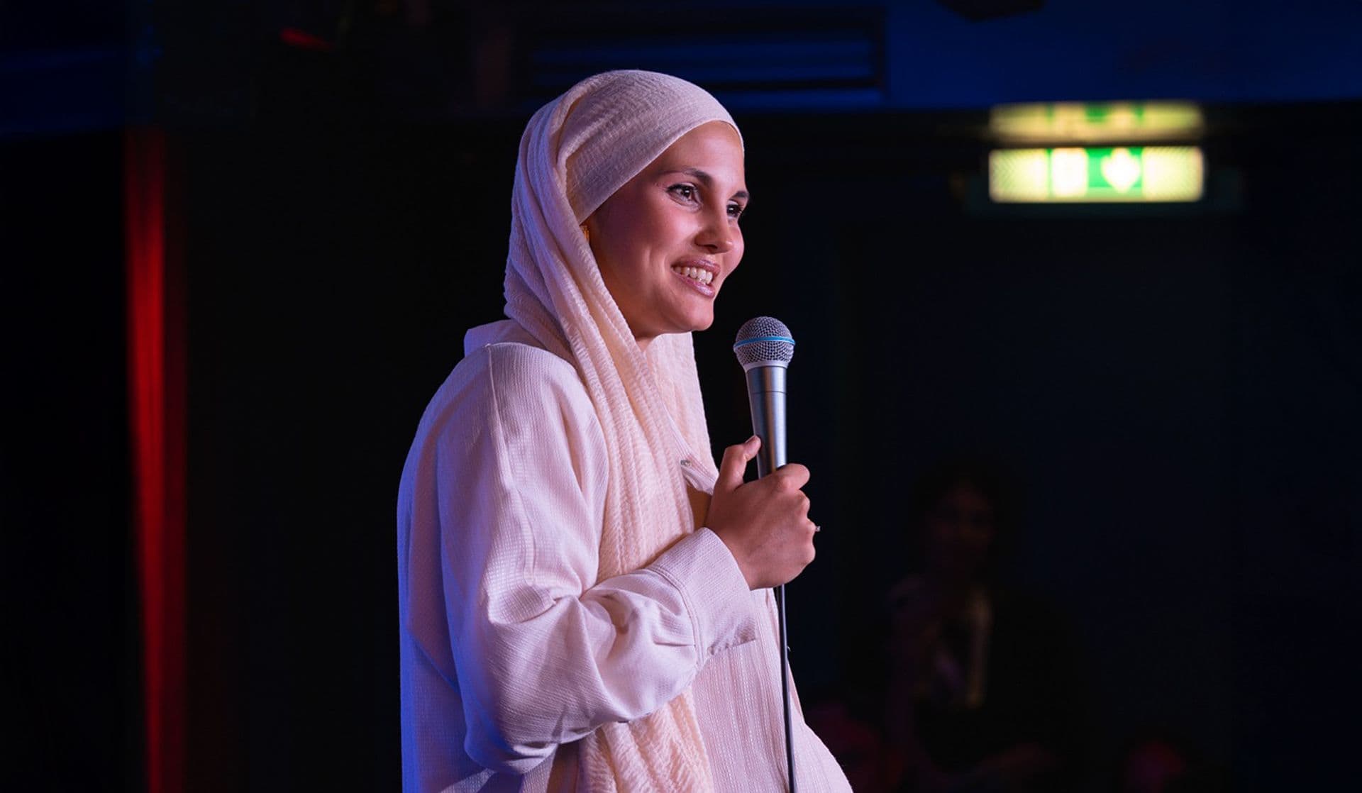 Anissa, eine weibliche Comedian mit muslimischen Kopftuch.